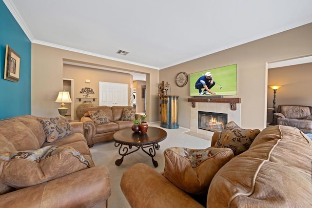 carpeted living room featuring a tile fireplace and crown molding