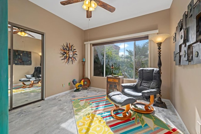 sitting room featuring concrete flooring and ceiling fan