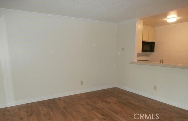 unfurnished room with crown molding and dark wood-type flooring