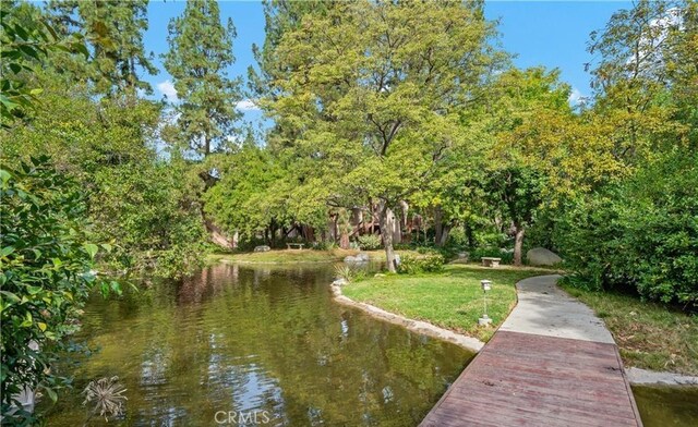 view of dock with a yard and a water view