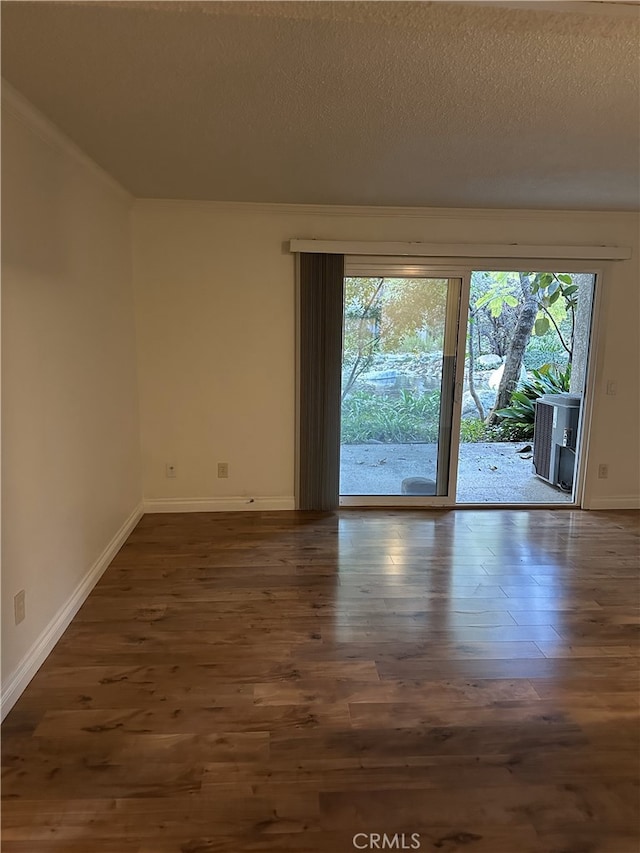 spare room with dark hardwood / wood-style floors and a textured ceiling