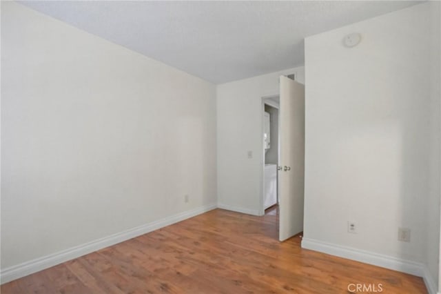 spare room featuring washer / dryer and light wood-type flooring