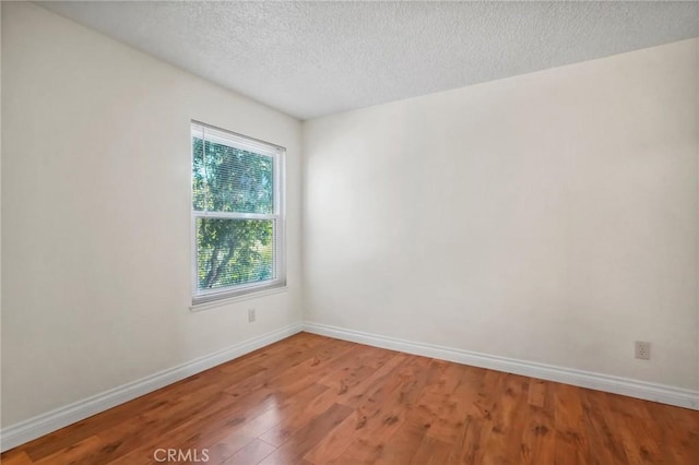 spare room with hardwood / wood-style flooring and a textured ceiling