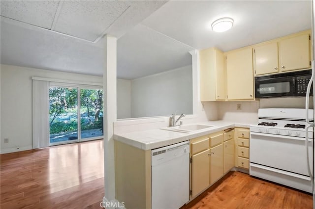 kitchen with sink, white appliances, cream cabinets, tile counters, and light hardwood / wood-style floors