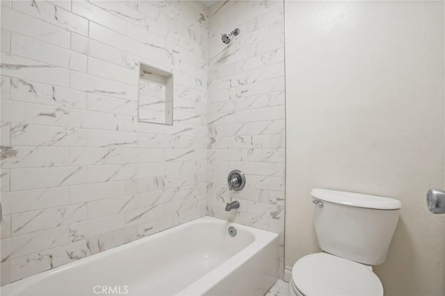 bathroom featuring tiled shower / bath combo and toilet