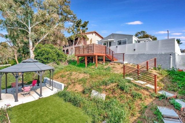 view of yard with a wooden deck, a gazebo, and a patio area