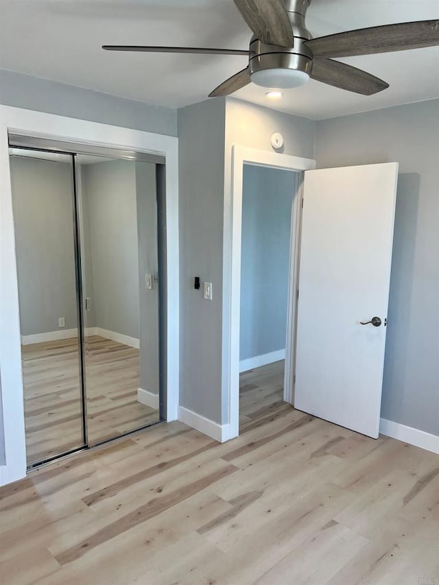 unfurnished bedroom featuring light hardwood / wood-style floors, a closet, and ceiling fan