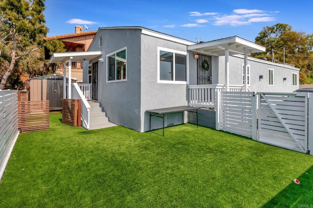 rear view of house with a yard and a storage unit