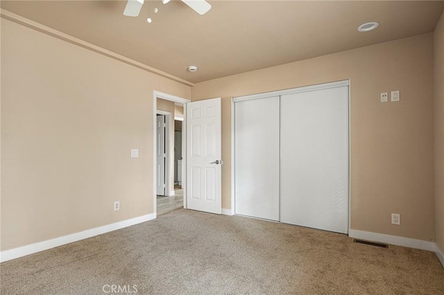 unfurnished bedroom featuring carpet floors, ceiling fan, and a closet