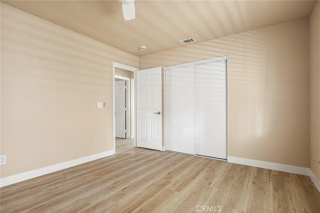 unfurnished bedroom featuring light hardwood / wood-style floors, a closet, and ceiling fan