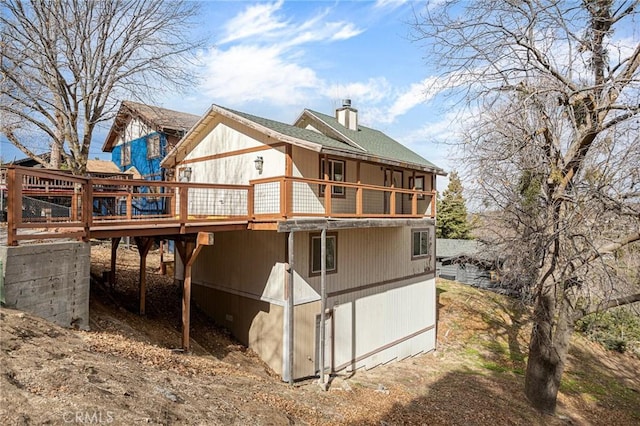 rear view of property featuring a wooden deck