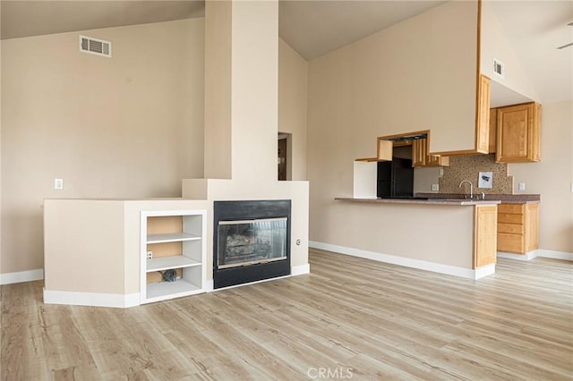 284 Davos Dr, Crestline, CA 92325 - unfurnished living room featuring high vaulted ceiling, baseboards, light wood finished floors, built in shelves, and a glass covered fireplace