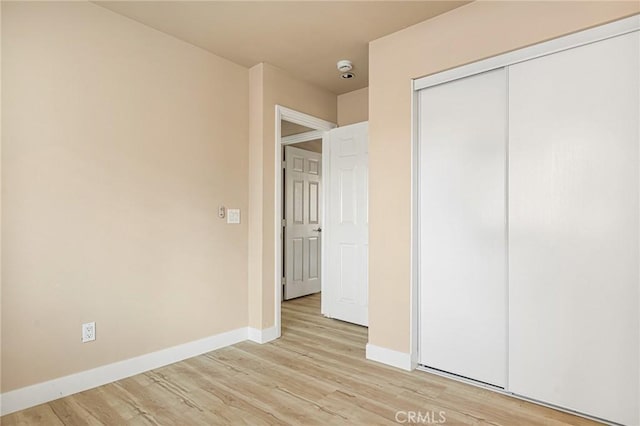 unfurnished bedroom featuring a closet and light hardwood / wood-style flooring