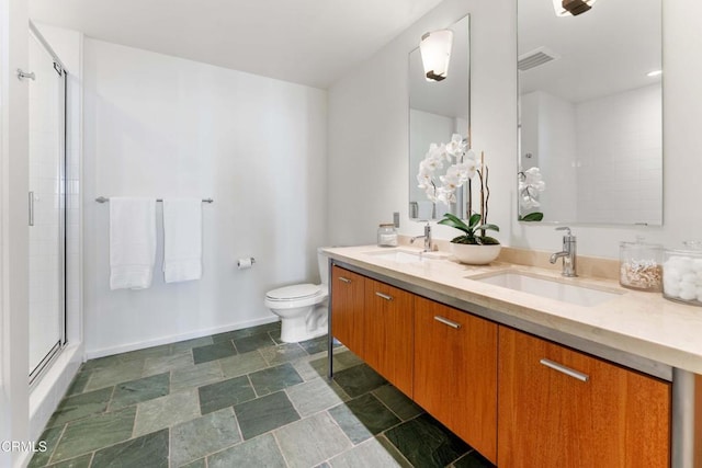 bathroom with vanity, toilet, and a shower with door