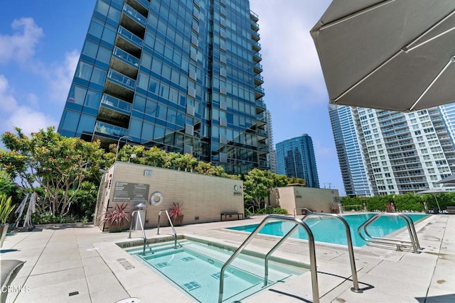 view of swimming pool with a community hot tub and a patio area