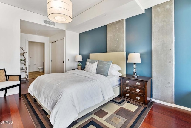 bedroom featuring dark wood-type flooring and a closet