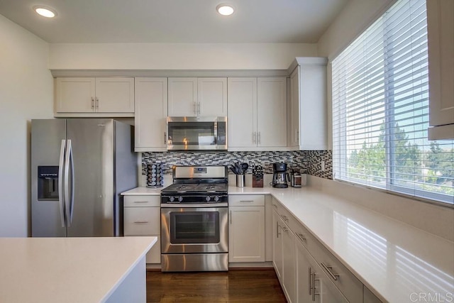 kitchen featuring stainless steel appliances, dark hardwood / wood-style floors, and decorative backsplash