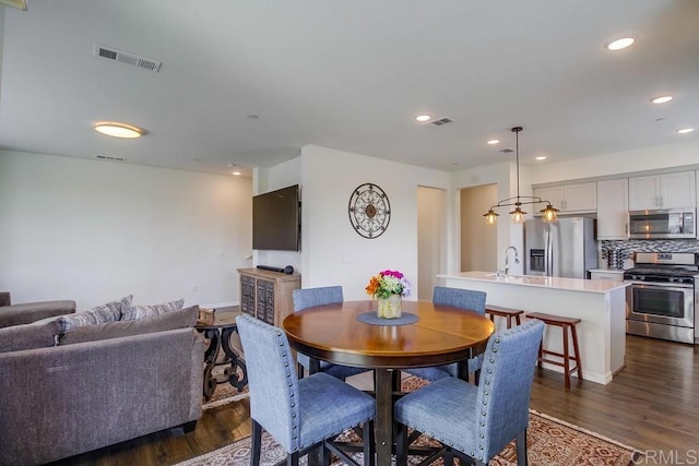 dining space featuring dark wood-type flooring and sink