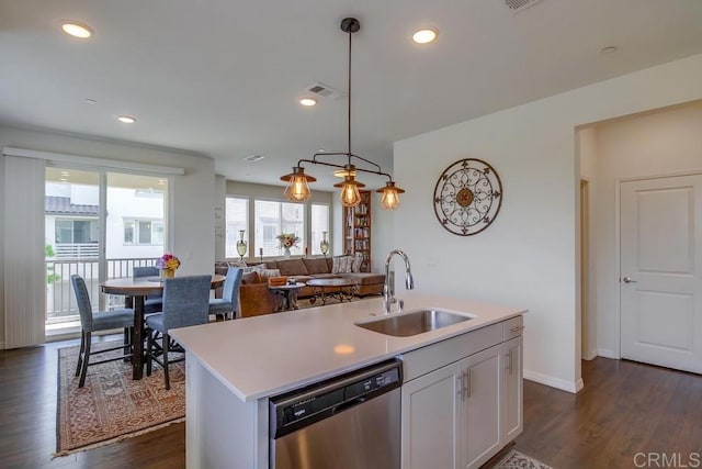 kitchen with sink, dishwasher, white cabinetry, hanging light fixtures, and a center island with sink