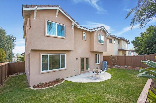 back of property featuring french doors, a patio area, and a lawn