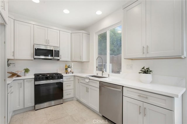 kitchen with white cabinetry, stainless steel appliances, and sink