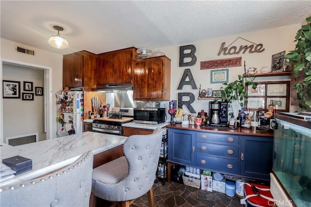 kitchen with tasteful backsplash, stainless steel appliances, and a textured ceiling