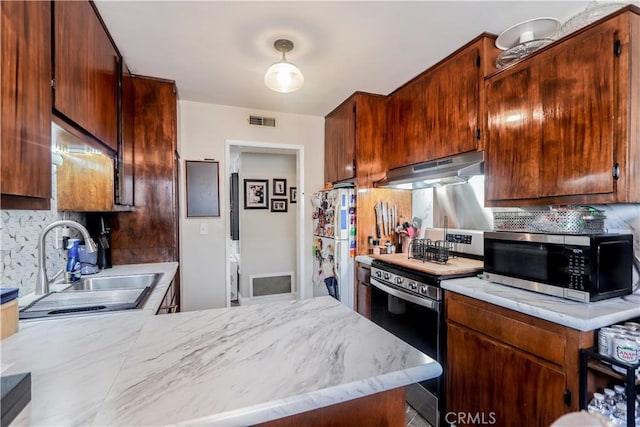 kitchen featuring sink, decorative backsplash, stainless steel appliances, and kitchen peninsula