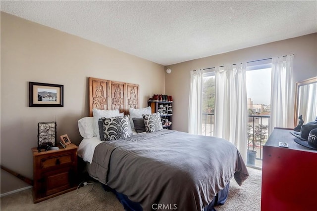 bedroom with access to exterior, a textured ceiling, and carpet