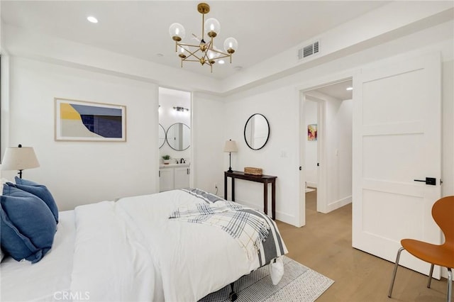 bedroom with a chandelier and light hardwood / wood-style floors