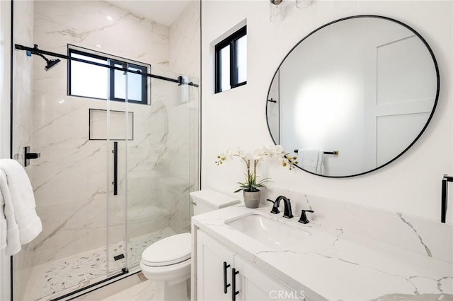 bathroom with vanity, toilet, and a shower with shower door