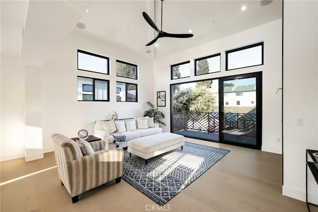 interior space featuring light hardwood / wood-style floors, ceiling fan, and a high ceiling