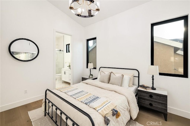 bedroom featuring vaulted ceiling, hardwood / wood-style floors, a notable chandelier, and ensuite bathroom