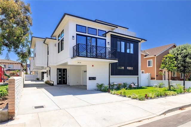 view of front facade with a balcony and a front lawn