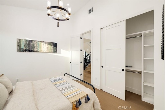 bedroom featuring wood-type flooring, a closet, and a chandelier