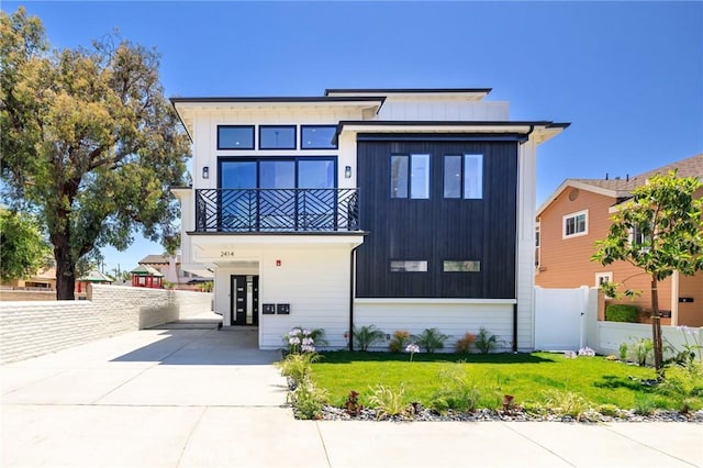 view of front of home with a balcony and a front lawn