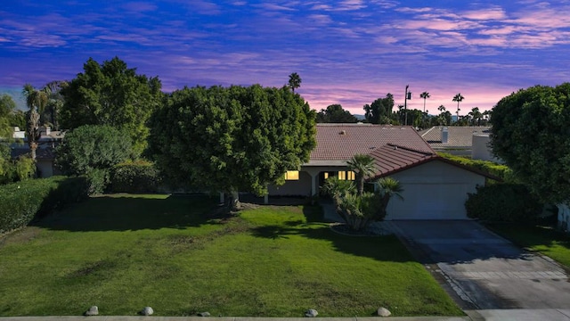 view of front of house with a garage and a lawn