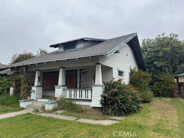 view of front of house with a front yard and covered porch