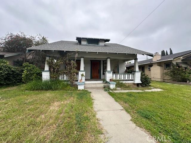 view of front of property with covered porch and a front yard