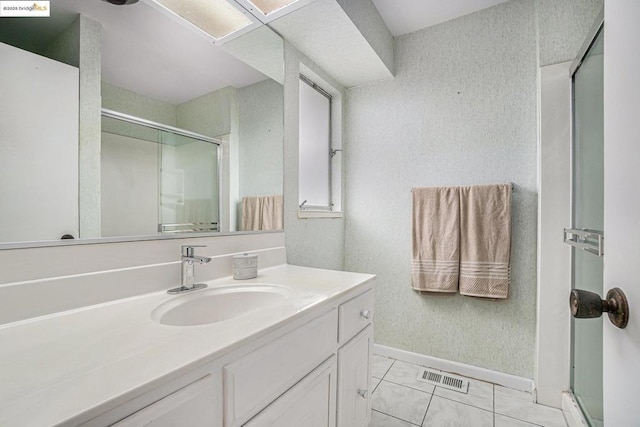 bathroom featuring tile patterned floors, vanity, and an enclosed shower