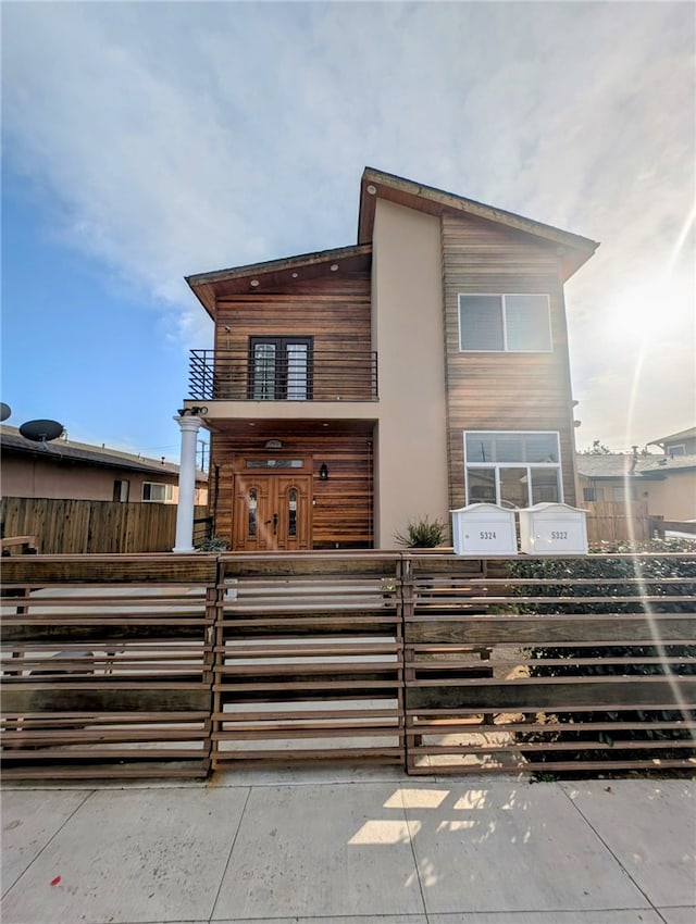 view of front of property with a balcony, a gate, and a fenced front yard