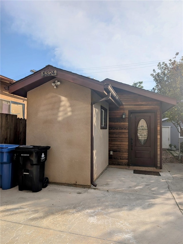 exterior space featuring a patio area, fence, and stucco siding