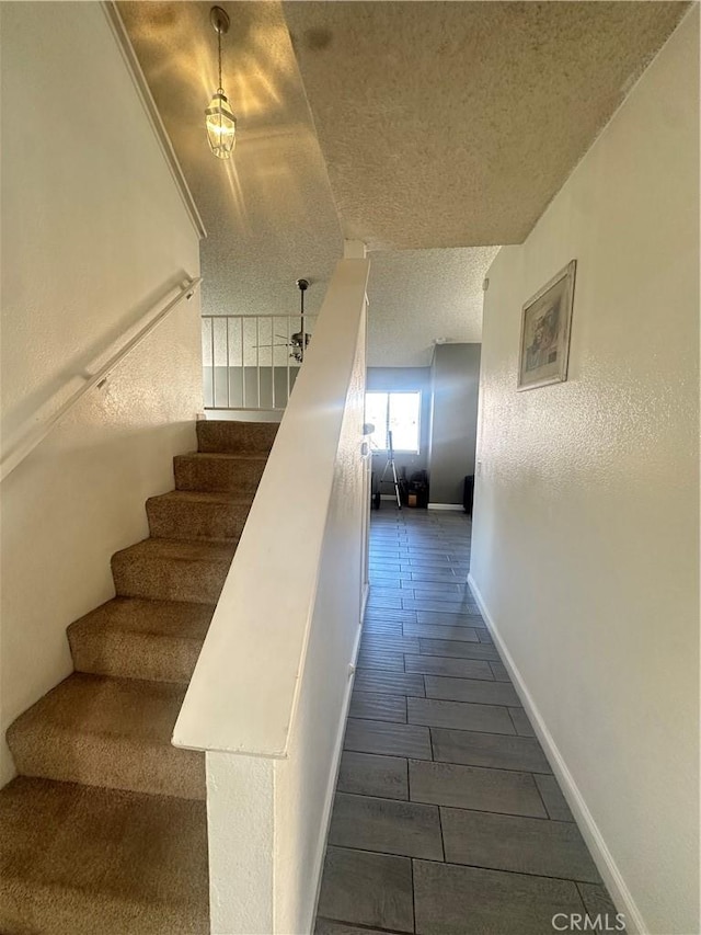 stairway with a textured ceiling