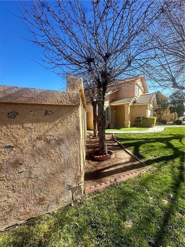 view of side of home with a lawn