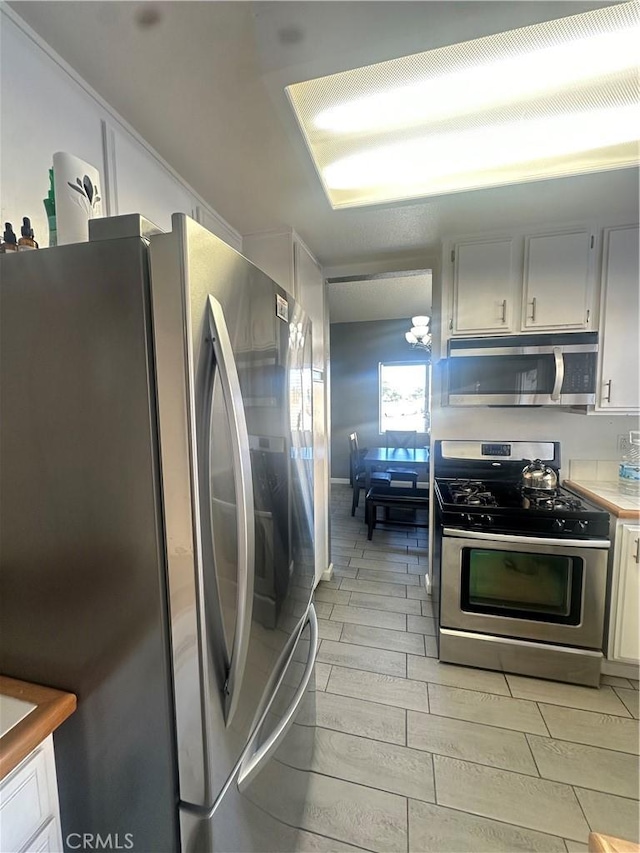 kitchen featuring stainless steel appliances and white cabinetry