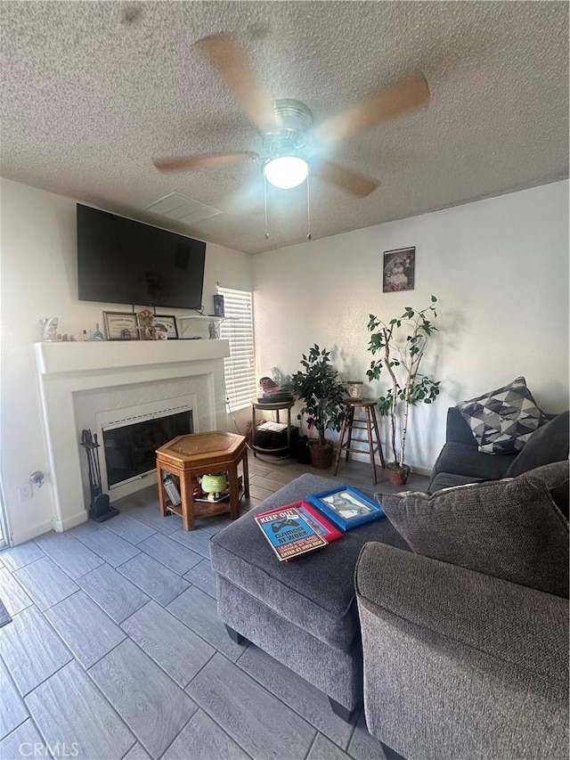 living room with a textured ceiling and ceiling fan