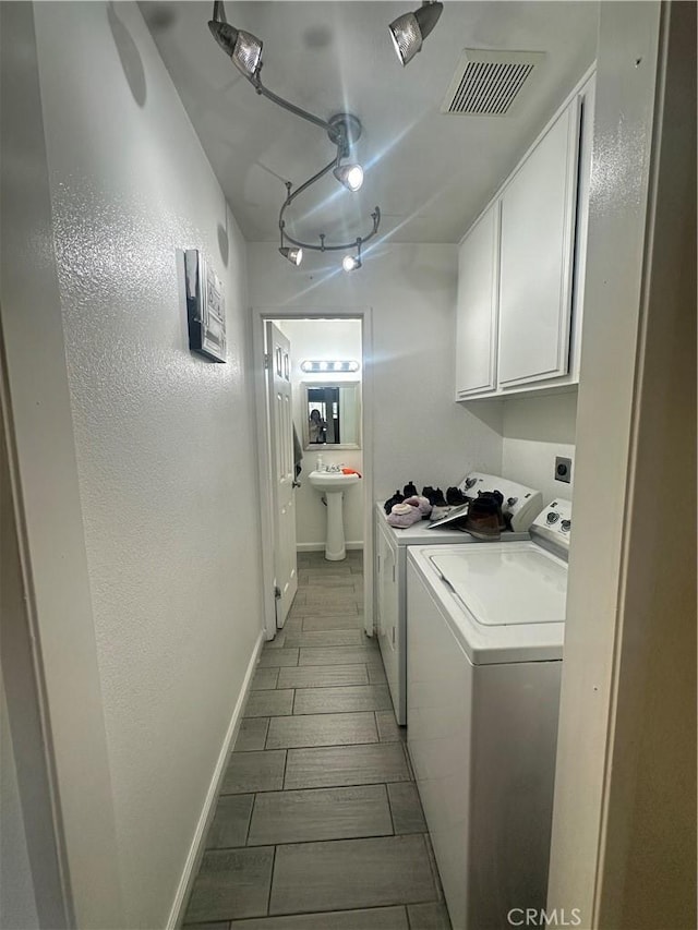 washroom with separate washer and dryer, sink, and cabinets