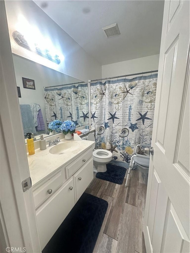 bathroom featuring vanity, hardwood / wood-style floors, and toilet