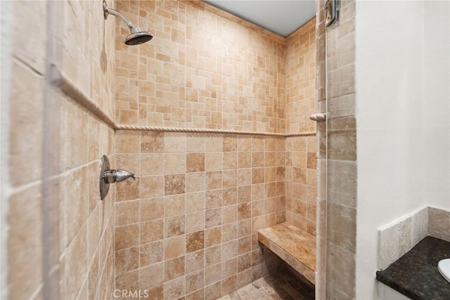 full bath with a tile shower and vanity