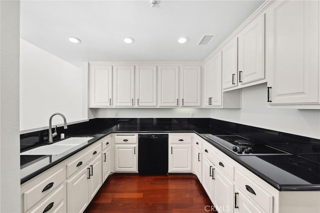 kitchen with dark countertops, white cabinets, a sink, and black appliances