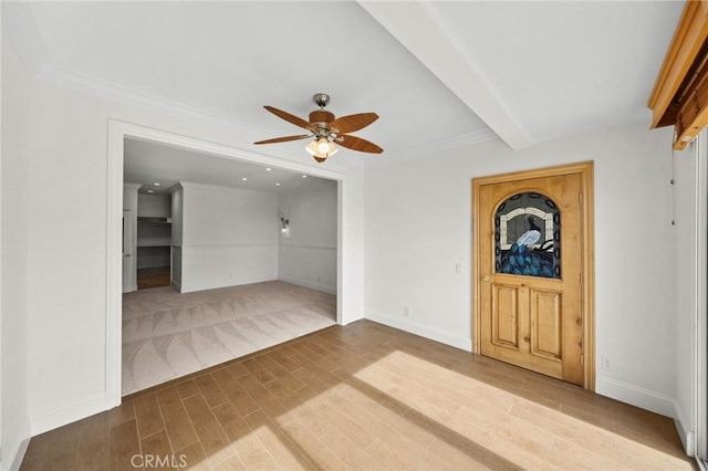 interior space featuring ceiling fan, crown molding, wood finished floors, and baseboards